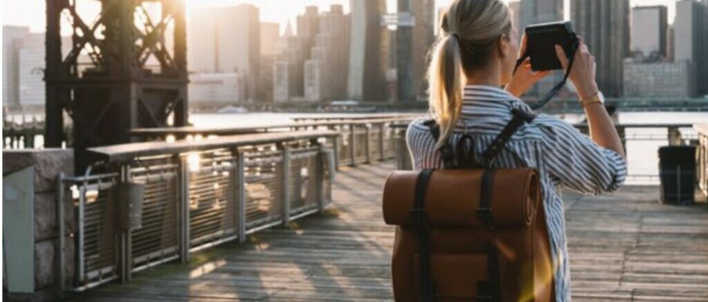 girl with bag back in new york city holding a camera