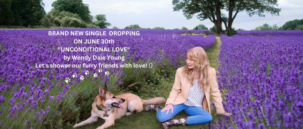 woman with her dog in sitting in green grass with purple flowers