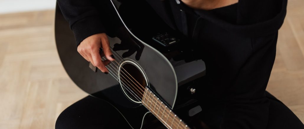 Person in black playing the guitar