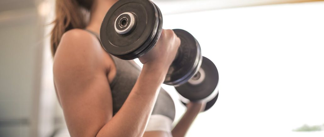 woman-in-gray-sports-bra-holding-black-dumbbell