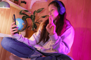  happy-cute-pretty-teen-headphones-joying-neon-room-home-girl-making-selfie-listen-music 