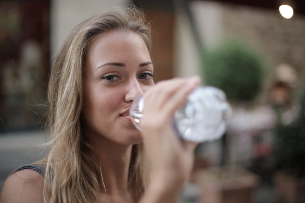 photo-of-smiling-woman-drinking-water-from-a-plastic-bottle-3763929/