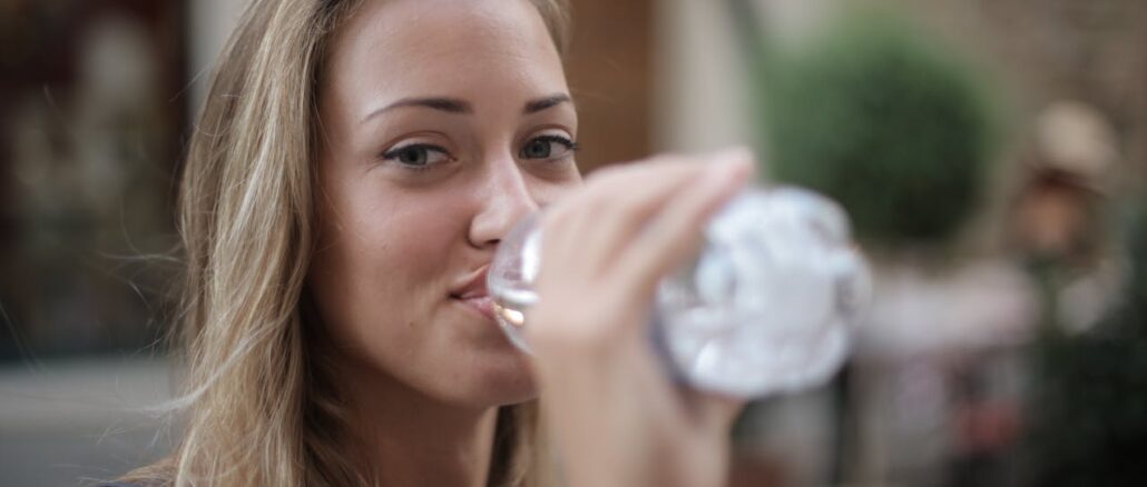 photo-of-smiling-woman-drinking-water-from-a-plastic-bottle-3763929/