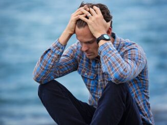 man-in-blue-and-brown-plaid-dress-shirt-touching-his-hair