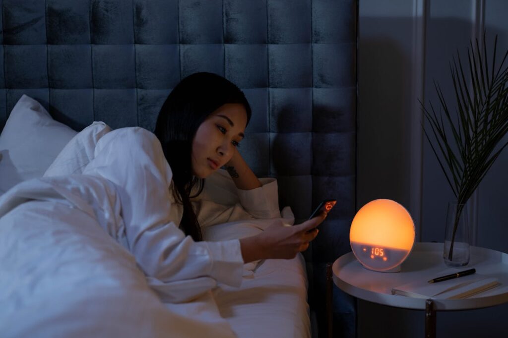 a woman lying in bed looking at a phone