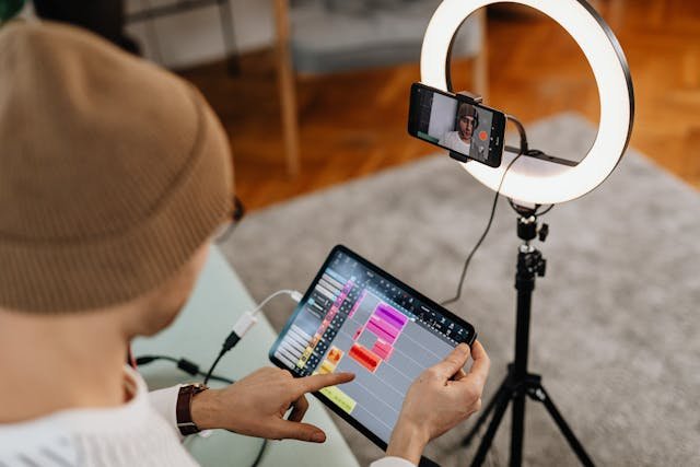 a person holding a tablet using ai tools in front of a ring light