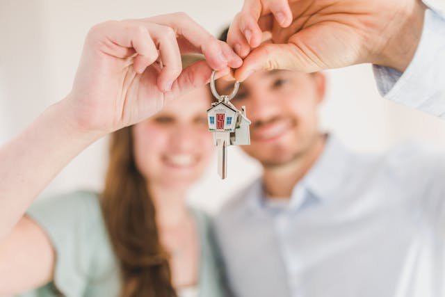 happy couple holding-and showing a home key