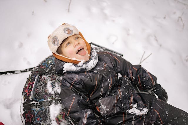 photo/a-kid-in-winter-clothing-having-fun-playing-in-the-snow