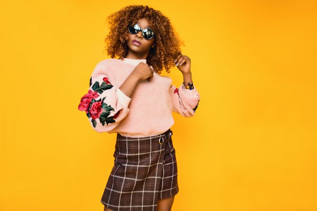 a woman wearing sunglasses and a pink sweater