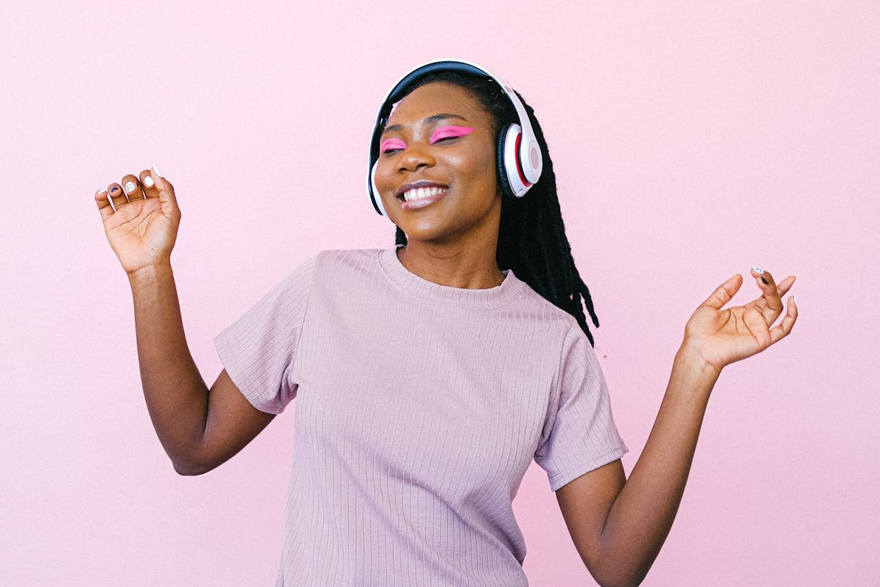 a happy woman dancing while wearing headphones