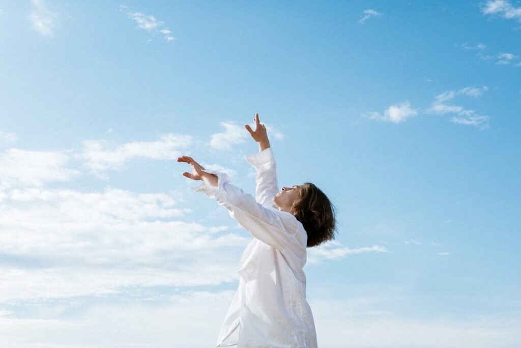 woman-in-white-long-sleeve-shirt-raising-her-hands-