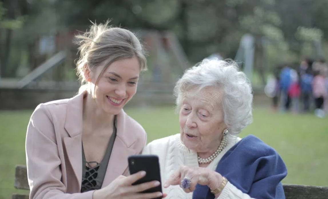 cheerful-senior-mother-and-adult-daughter-using-smartphone-together