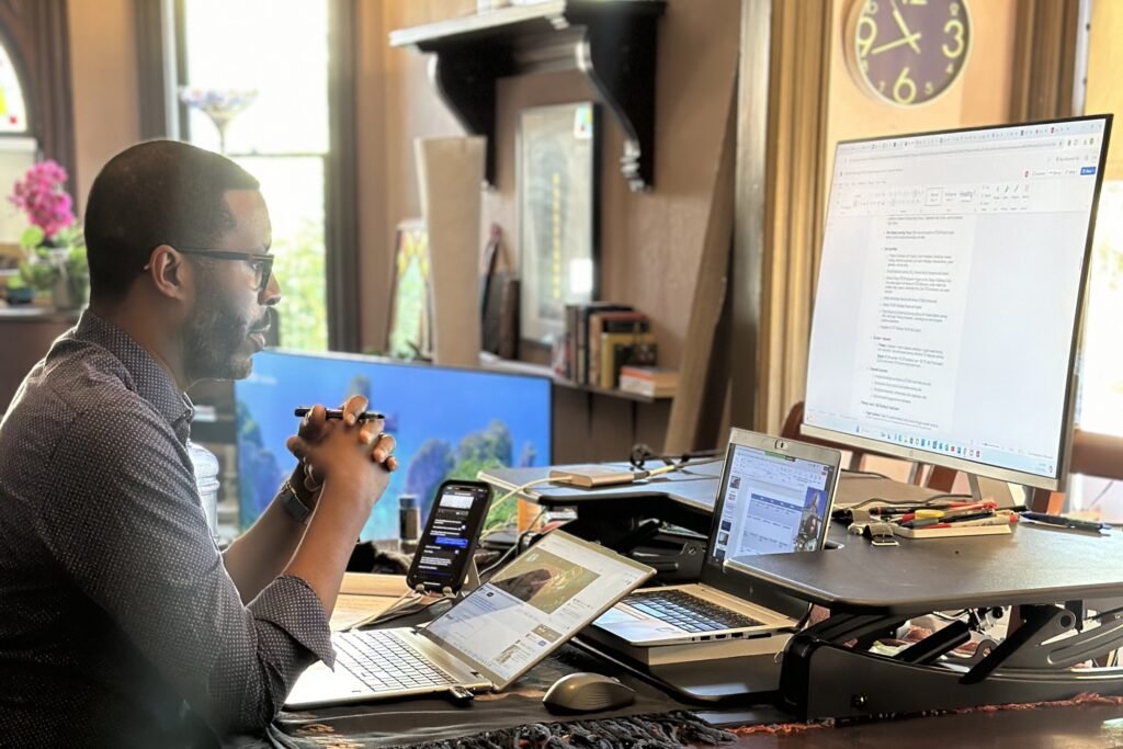 •	Dominick Robinson working after hours at his home desk, facilitating a virtual meeting with community partners to advance education initiatives.