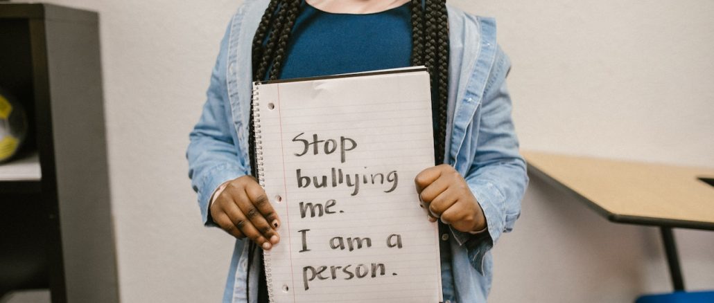 anti bullying sign holding by black little girl